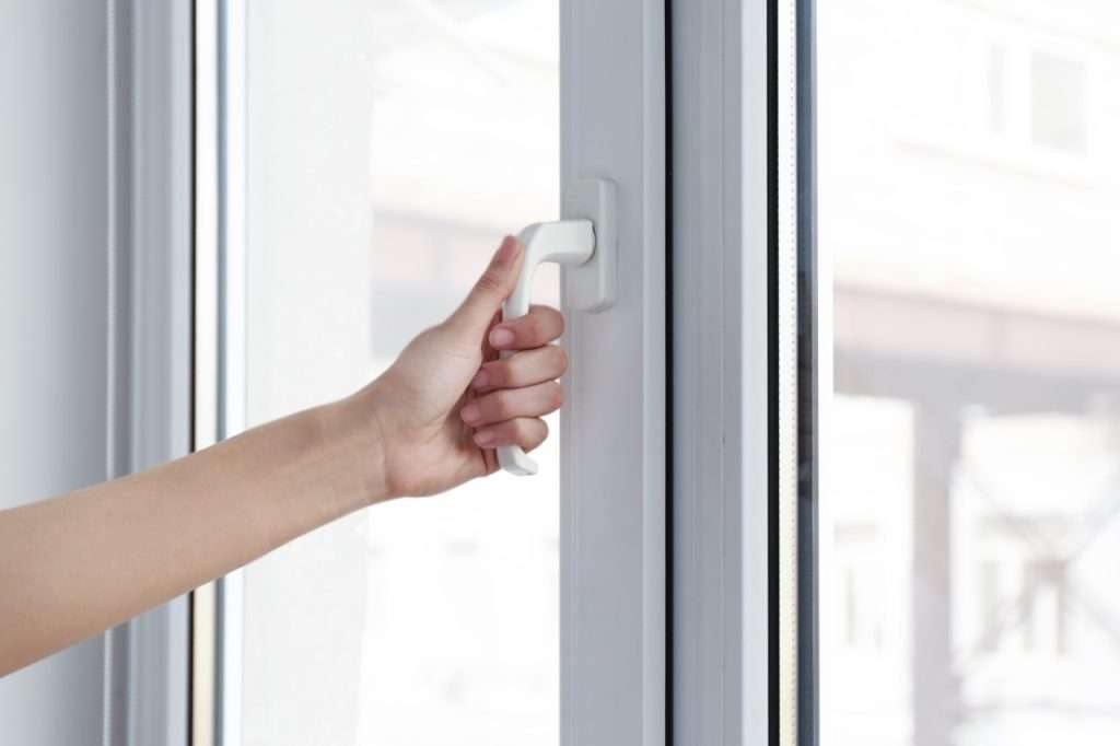 Young Woman Opening Window In Flat quality tilt & turn windows installation and replacement - 7