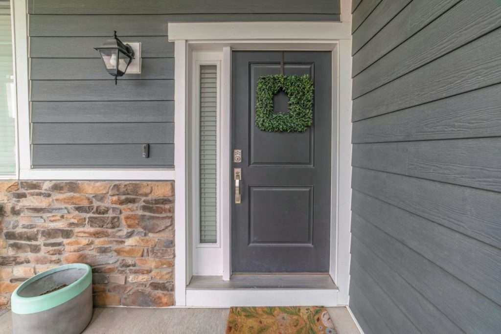 Entrance To A House With Side Light And Gray Front Door Decorated With Wreath about - 2